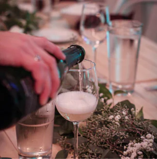 A person pouring a glass of white wine